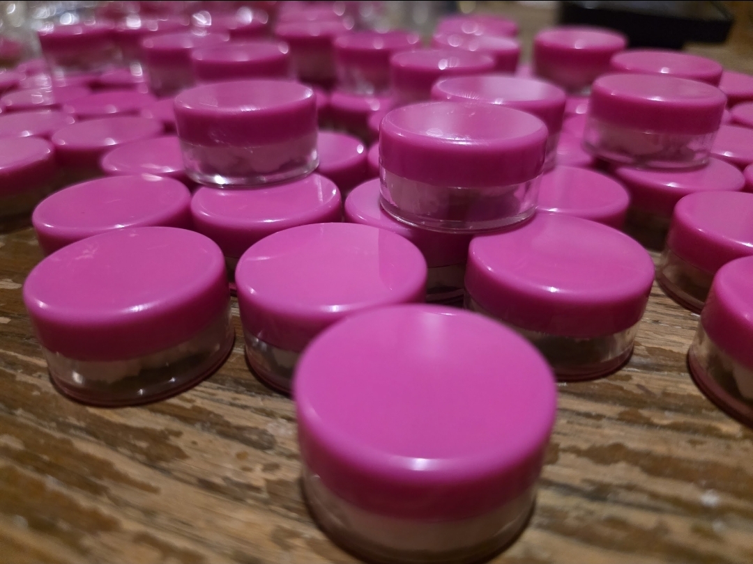 Rows of small pink sample jars